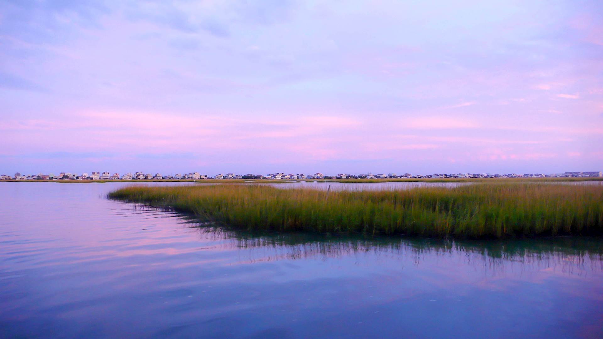 beautiful sunset setting over water and marshlands in the barrier island creekside waters of the South Carolina coast