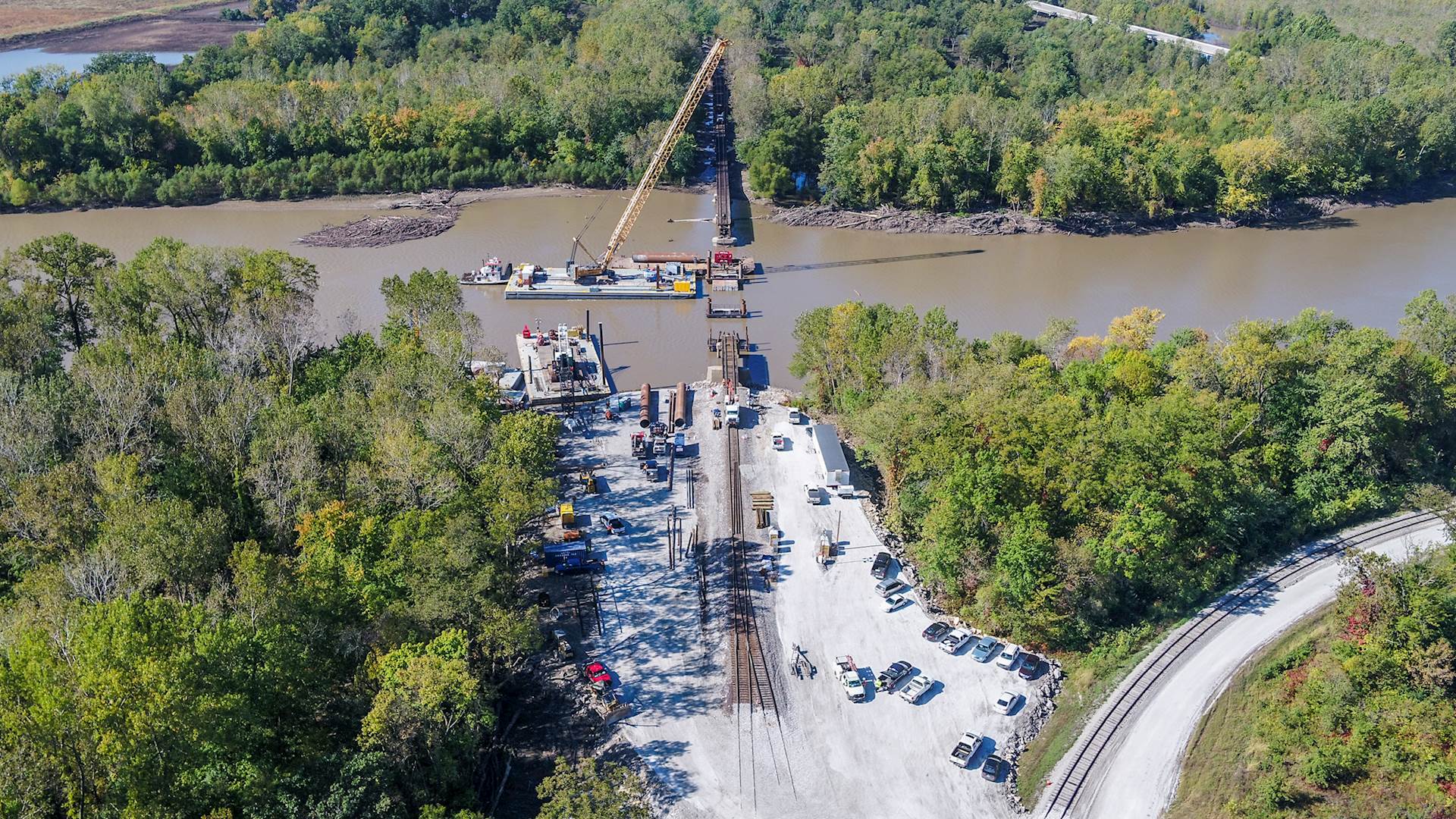 Reconstruction takes place for washed-out bridge over river.