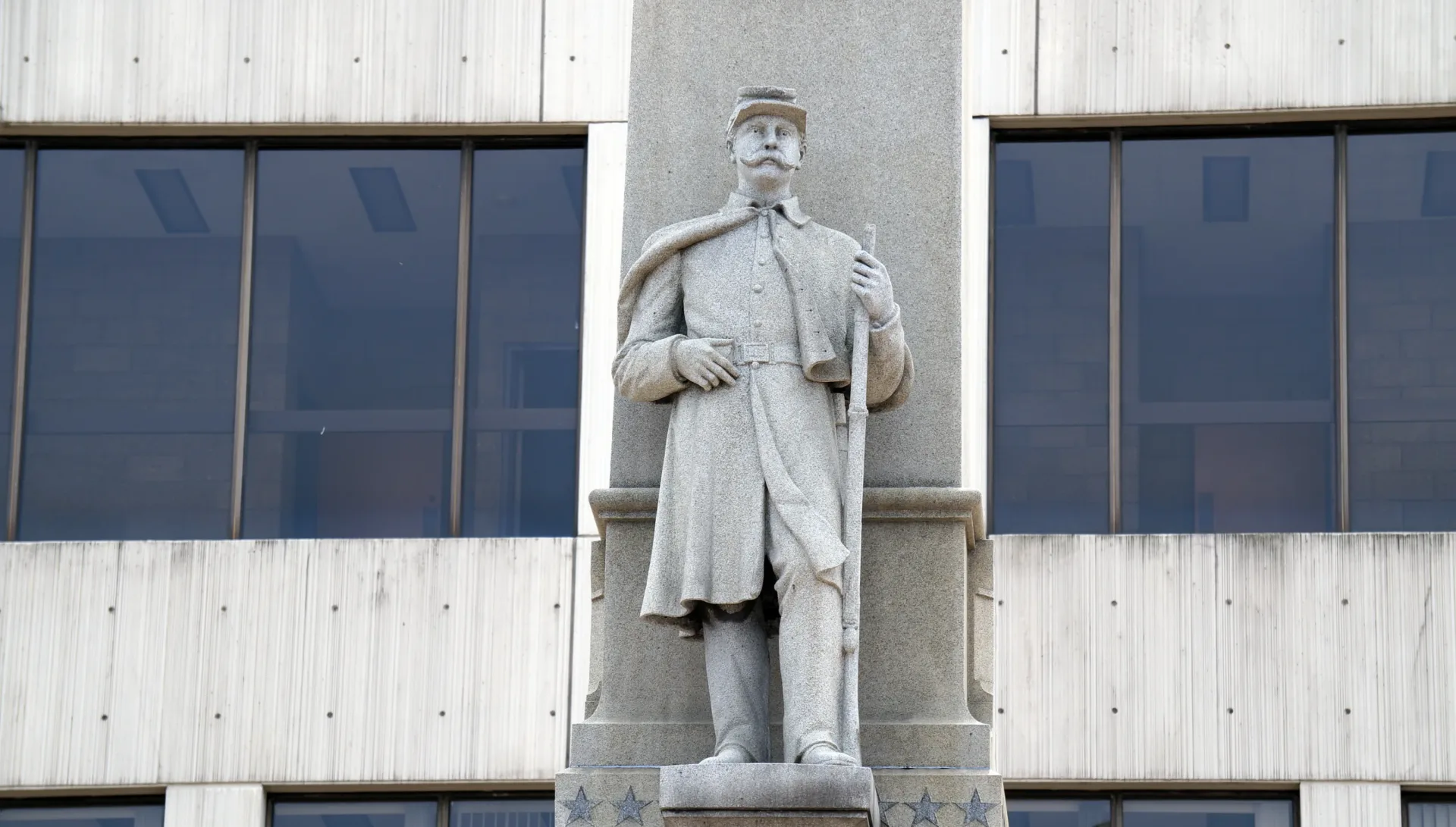 A figure of a Union Army soldier officer holding a rifle stands on the Will County Civil War Memorial, aka the Soldiers and Sailors of Civil War Monument, erected in front of the Will County Courthouse in Joliet, Illinois in 1884.