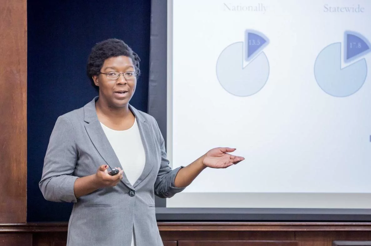 a woman stepping out from a lectern to speak