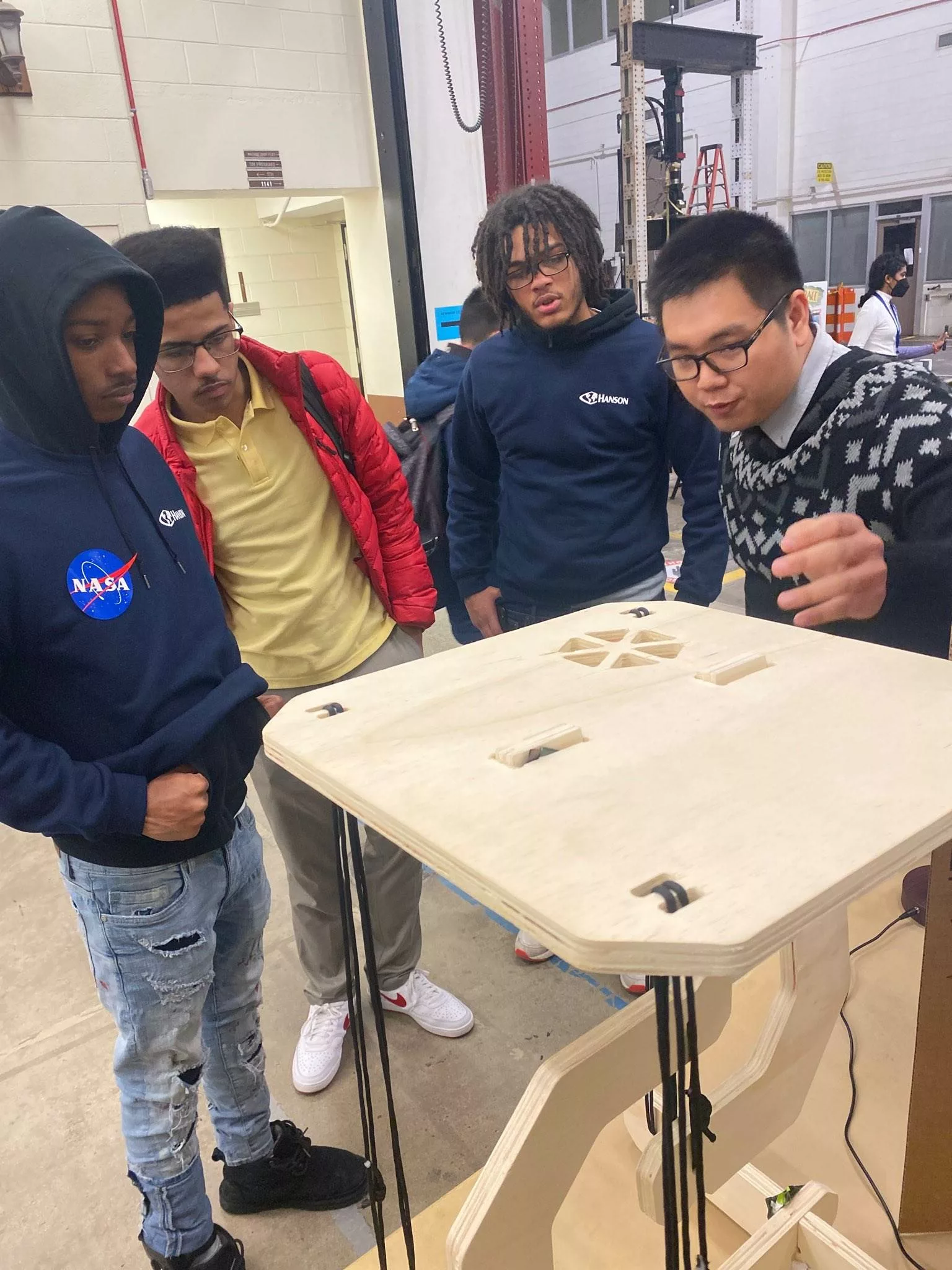 a student explains an exhibit to a group of other younger students