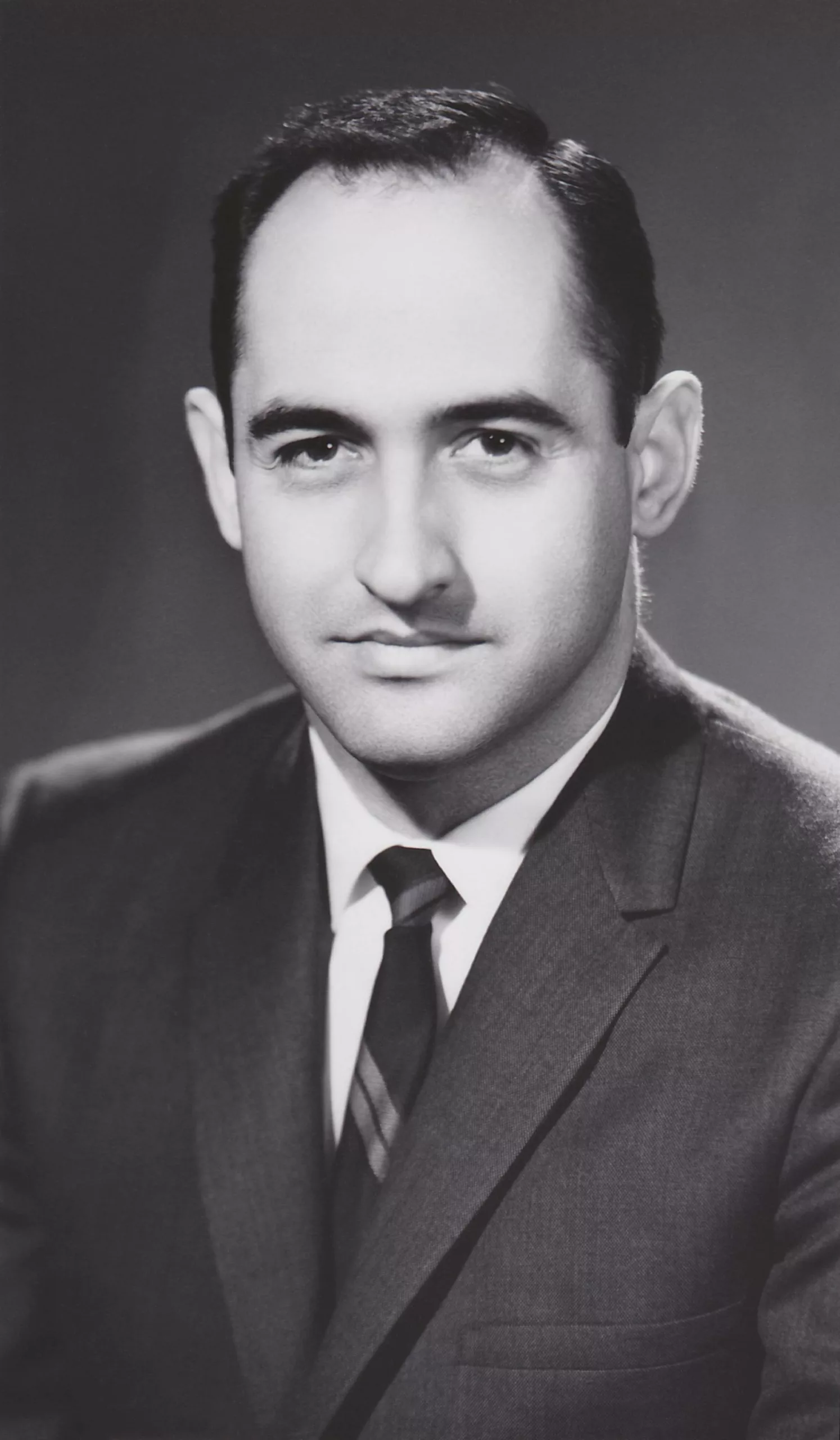 black and white headshot of Gene Wilkinson in dark suit jacket