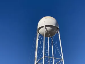 White water storage tank with blue sky in background