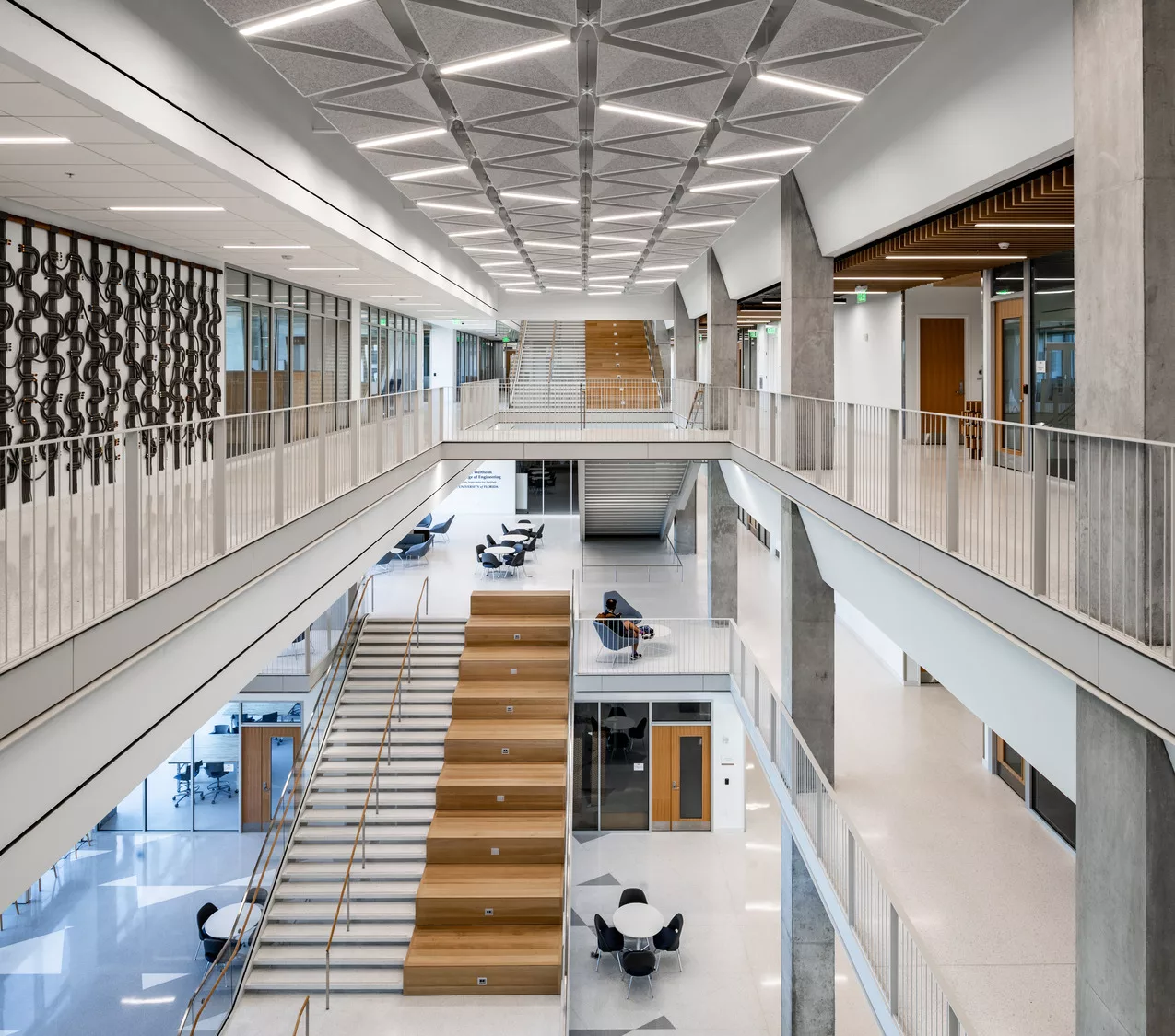 Interior of university building, looking across of room at staircases and decorative ceiling