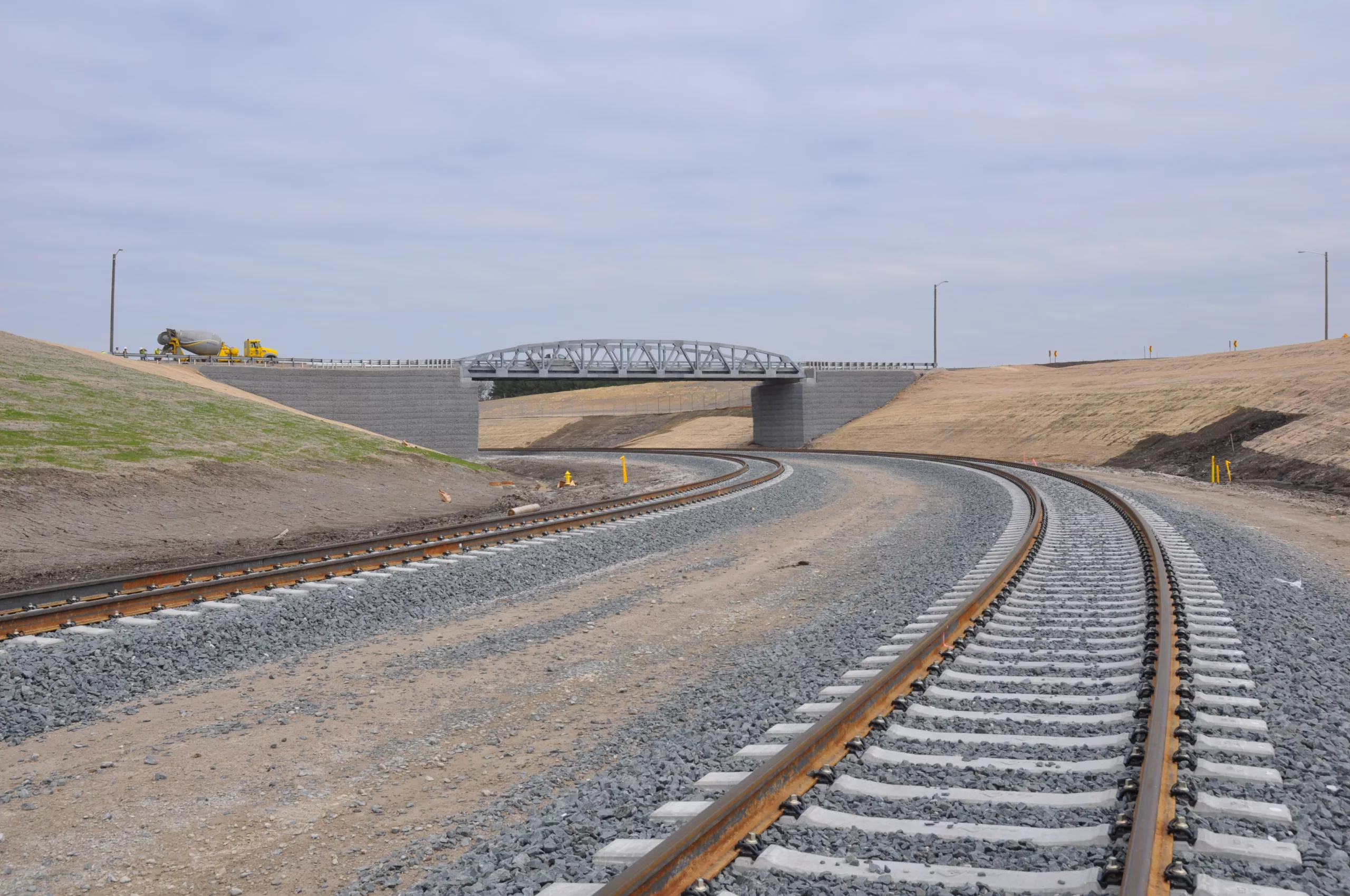 Railroad track running under bridge in distance
