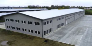 Airport hangar, surrounded by concrete, with gray sky in background