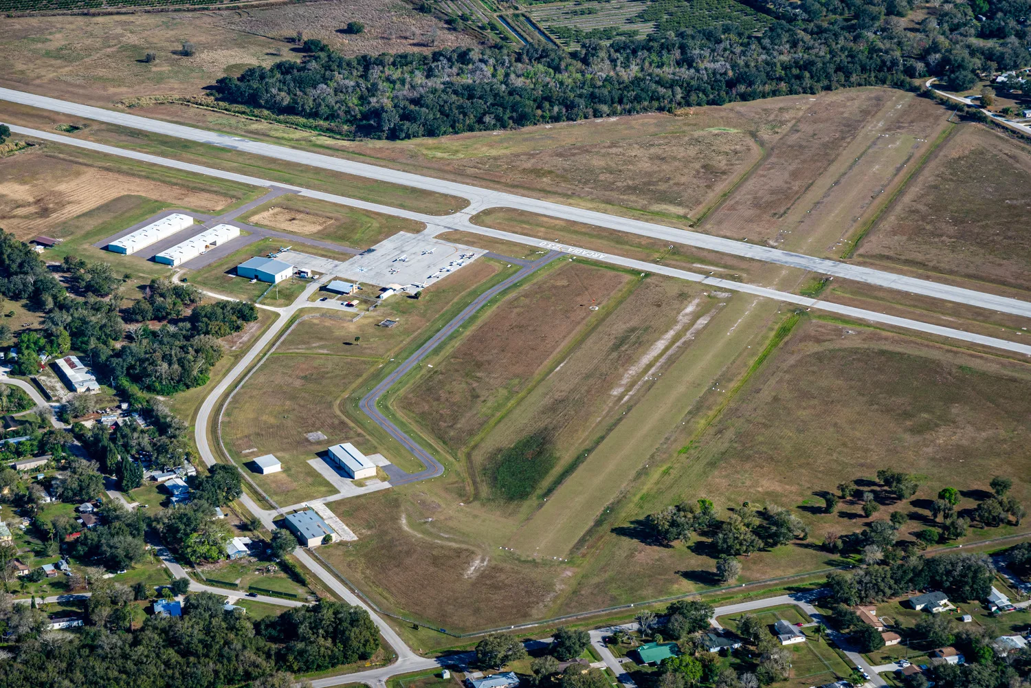 Aerial scene of airport with runways, buildings and trees
