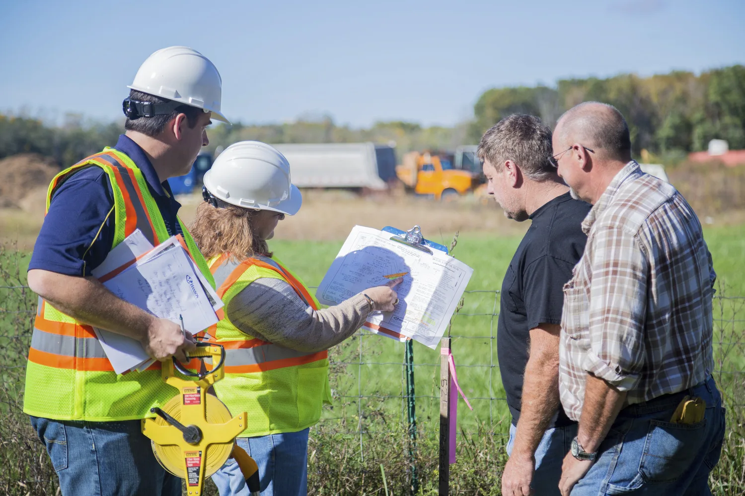 Group of people at project site with surveying tools and safety vests