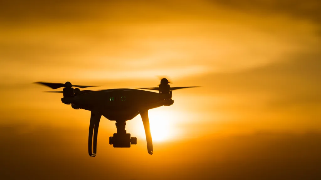 drone quad copter with digital camera at sunset ready to fly for surveillance. close-up of Rotor drones. 4 blade propeller drone. silhouette drone on sunset. Drone Video Camera.