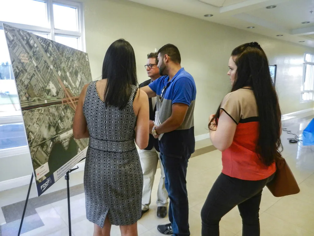 Several people look at an exhibit at a public involvement meeting