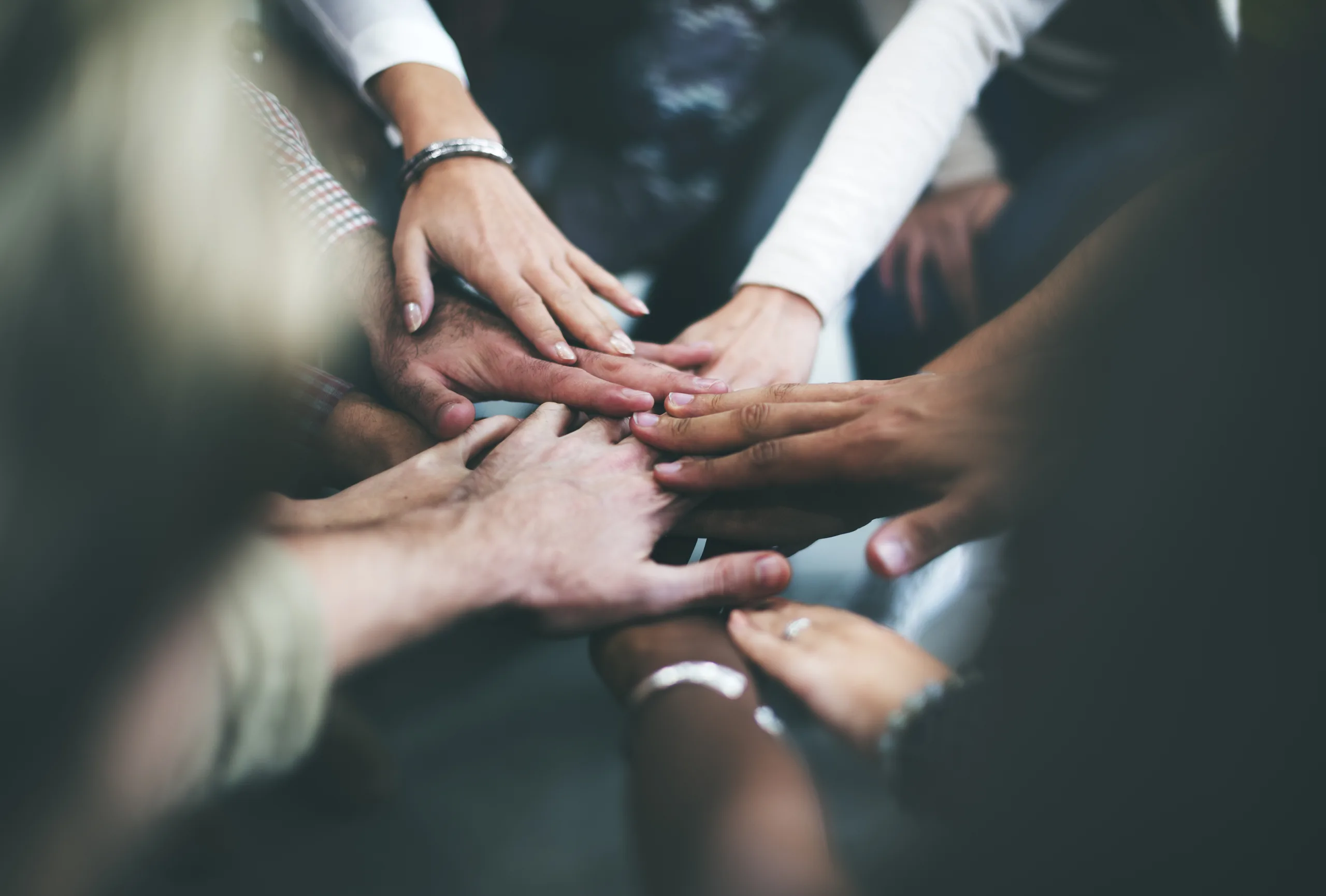 Close-up concept image of hands coming together in collaboration