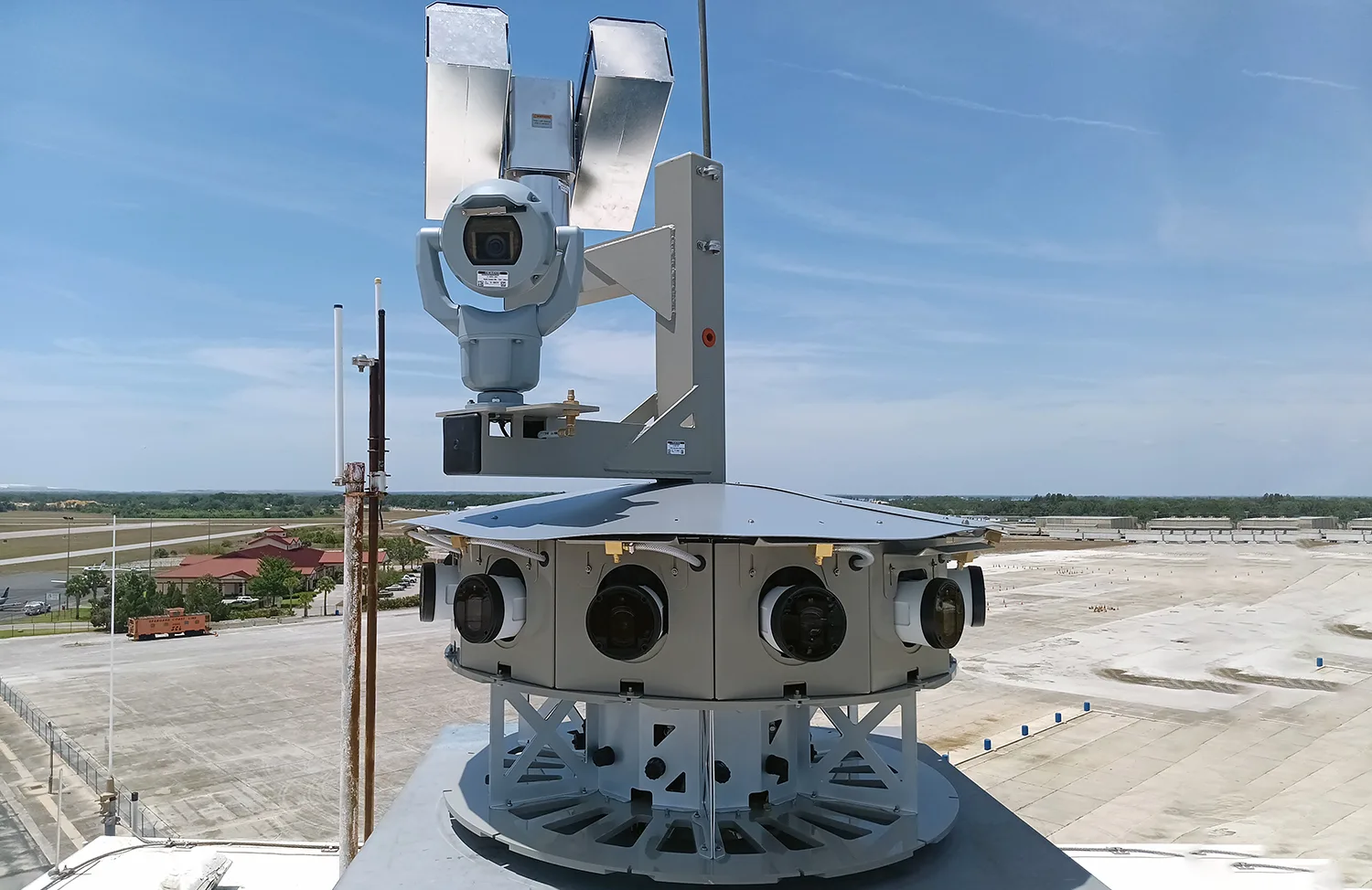 close-up of a remote control tower at an airport. tower has revolving set-up of cameras with another camera visible on top