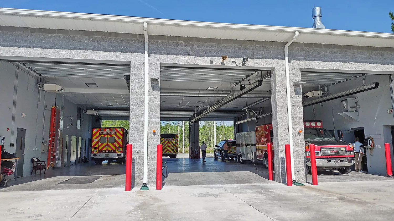 Close-up shot of three open fire station garages with ambulances parked inside