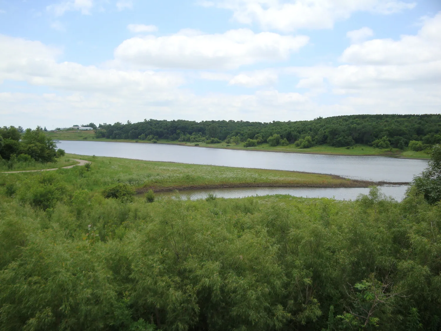 Photograph of a waterway with greenery in the foreground and background
