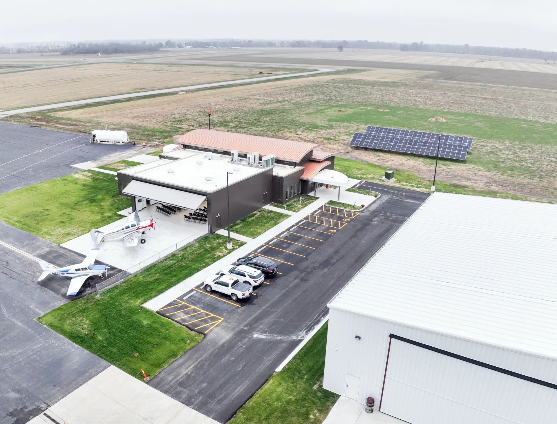 Aerial photo of new airport terminal and hangar with solar panels and farmland in background