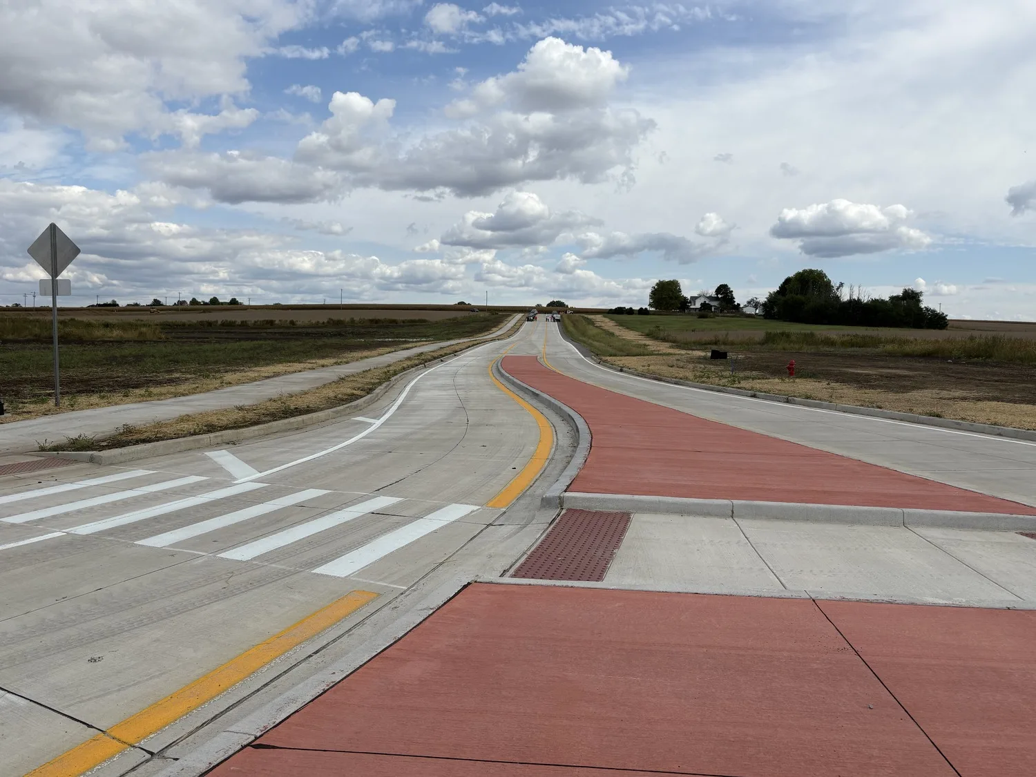 Ground view of a roadway with a median and cars in the background