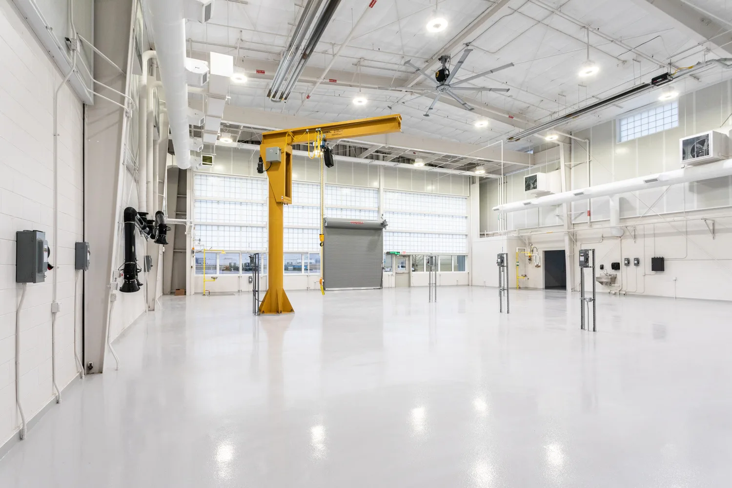Photo of the interior of a military building with white floors and walls and a yellow piece of equipment to the left