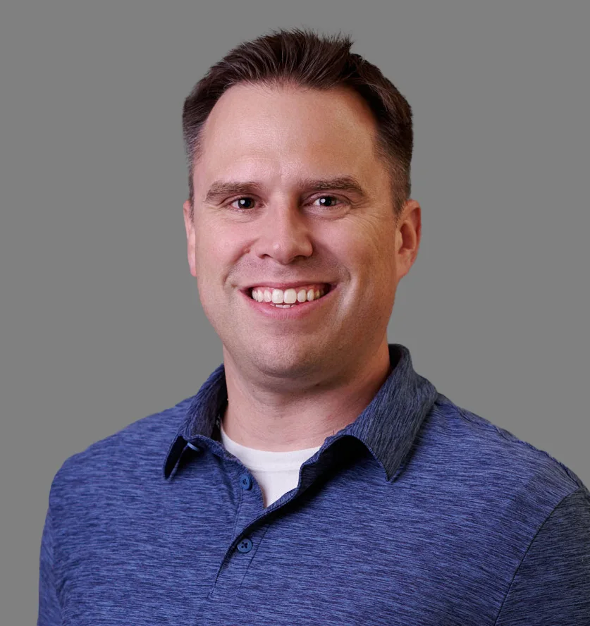 Headshot of Mike Quill wearing blue heathered shirt over white tee shirt