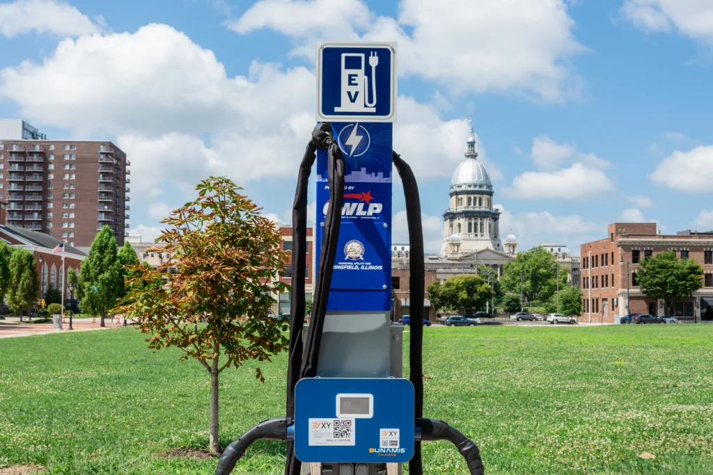 Electric vehicle charger in foreground with downtown buildings in background