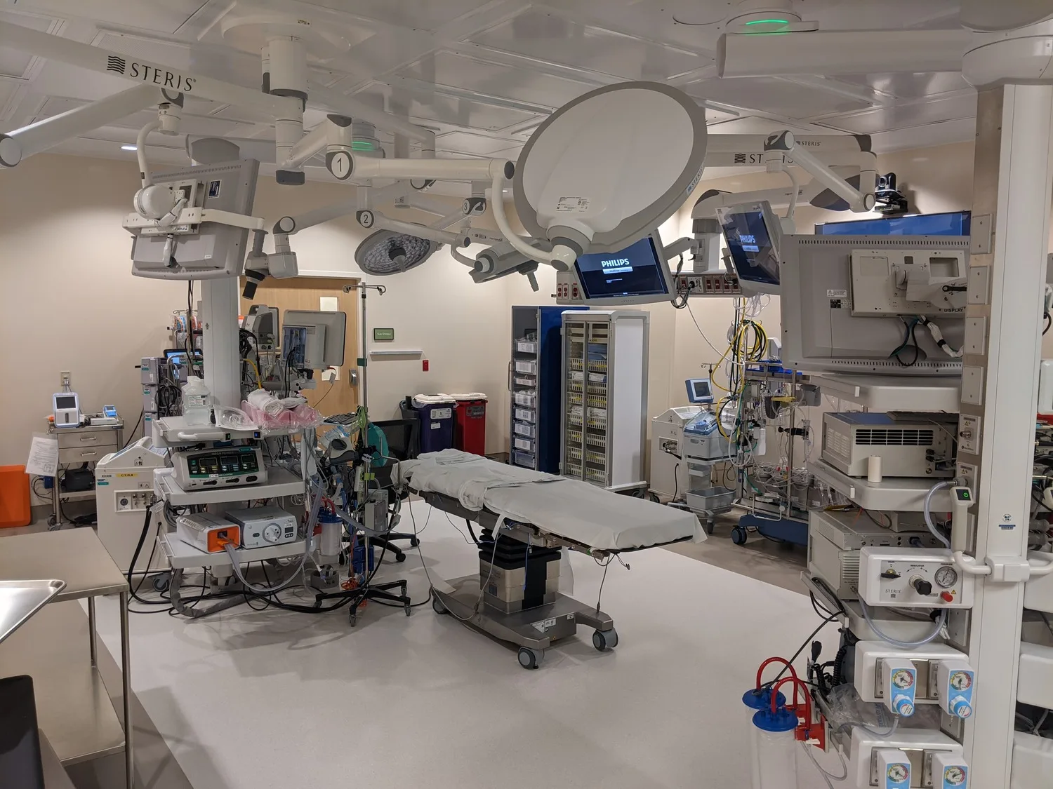 Interior photo of surgical room with gurney and many pieces of equipment